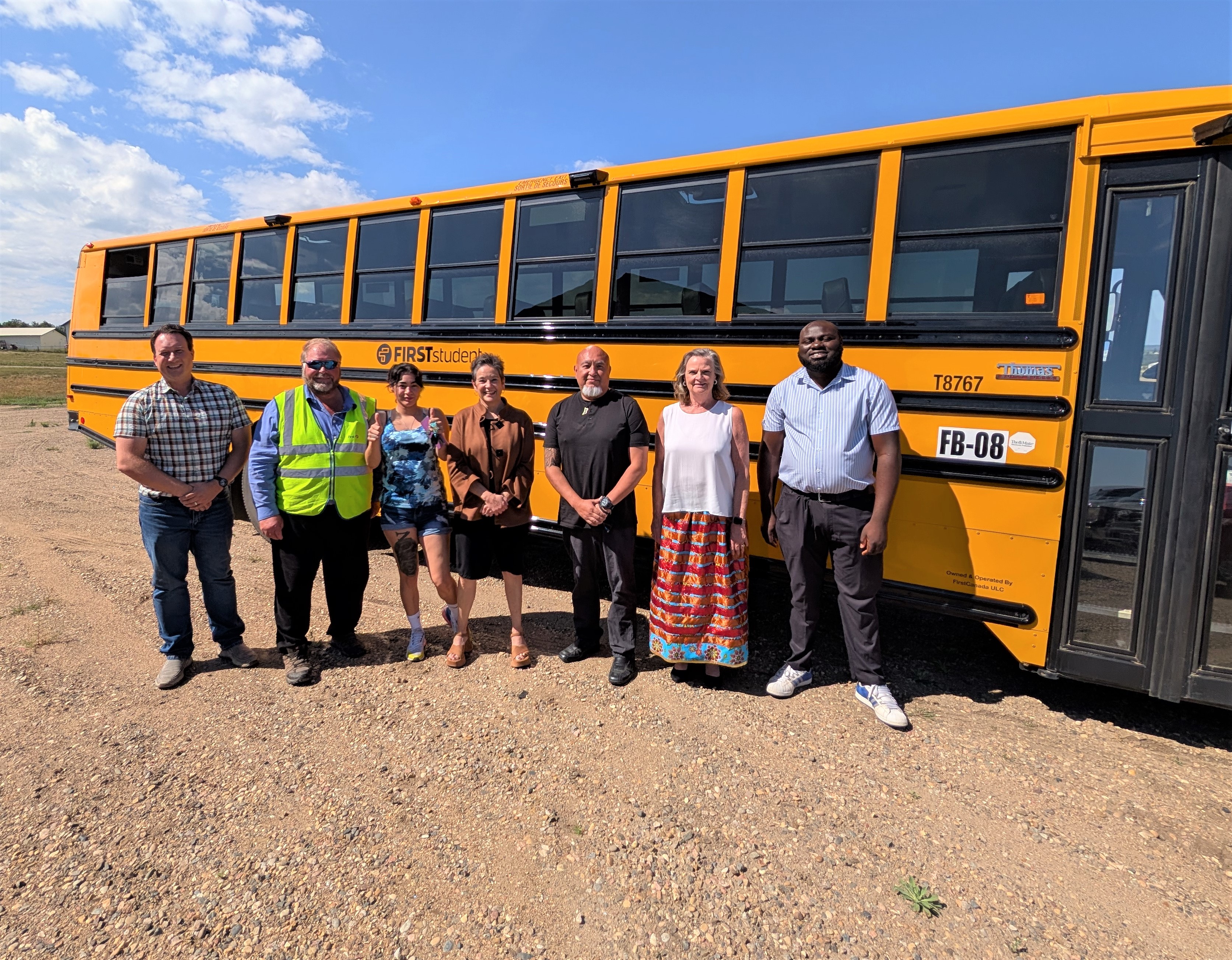 group of people in front of a school bus